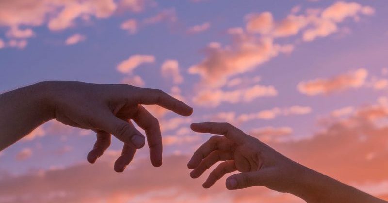 people reaching hands to each other