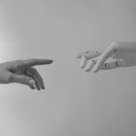 black and white photo of human hand and robot hand